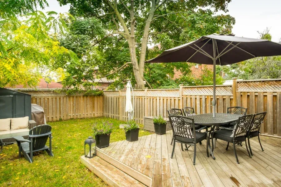 Timber garden deck with furniture and a parasol