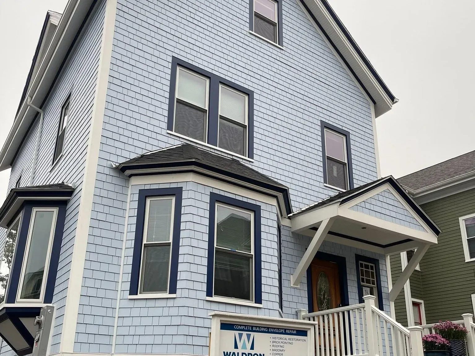 Grey clapboard and shingle siding with new trim and windows on a Boston home