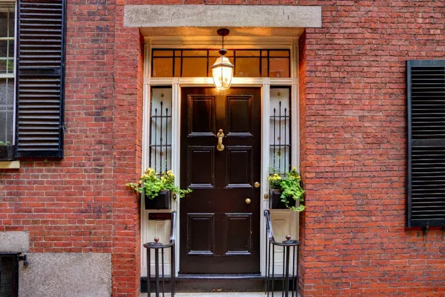 Restored brick facade with a panelled door and carriage lantern