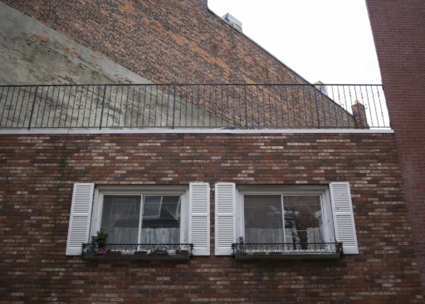 Brick elevation with repaired sills and painted shutters