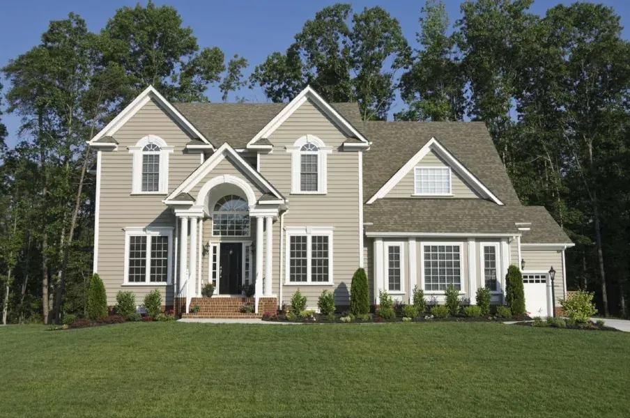 Completed asphalt shingle roof on a grey clapboard house