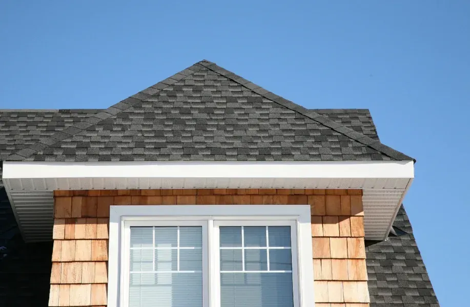 Cedar shingle siding and trim beside a replacement roof